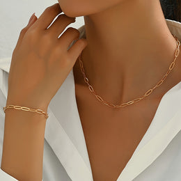 Model wearing the gold-tone chain-style necklace and bracelet set