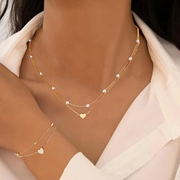 Variant-linked gold-tone layered necklaces and bracelet worn together