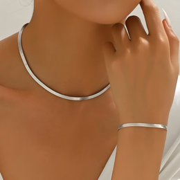 Model wearing the smooth silver-tone necklace and bracelet set