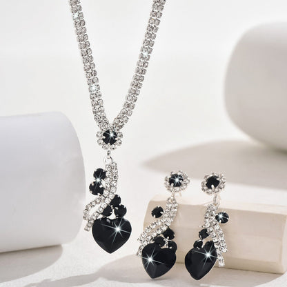 Black-detail necklace and earrings on a white display