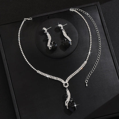 Black-detail necklace and earrings on a black display