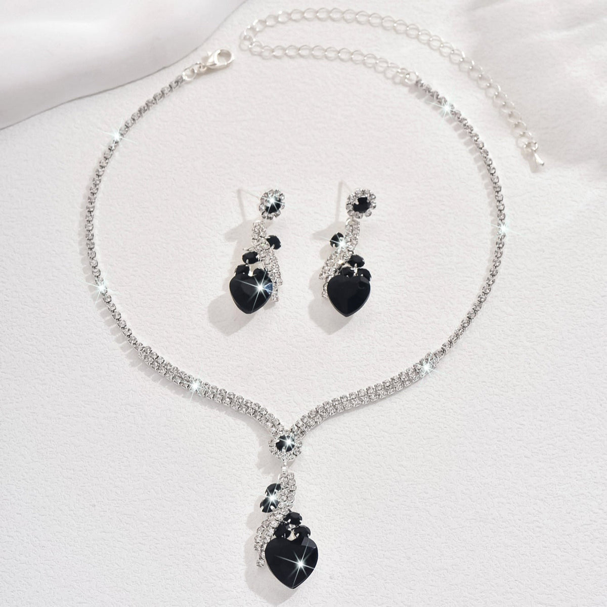 Black-detail necklace and earrings on a white background