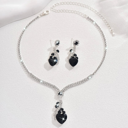 Black-detail necklace and earrings on a white background