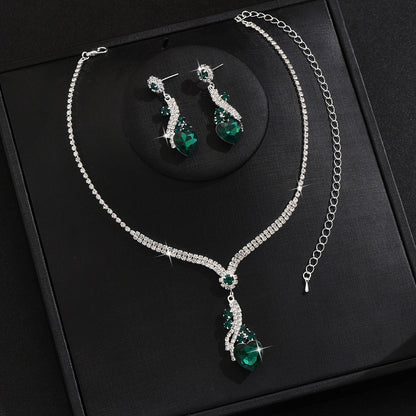 Green-detail necklace and earrings on a black display