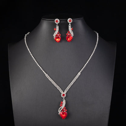 Red-detail necklace and earrings on a black display